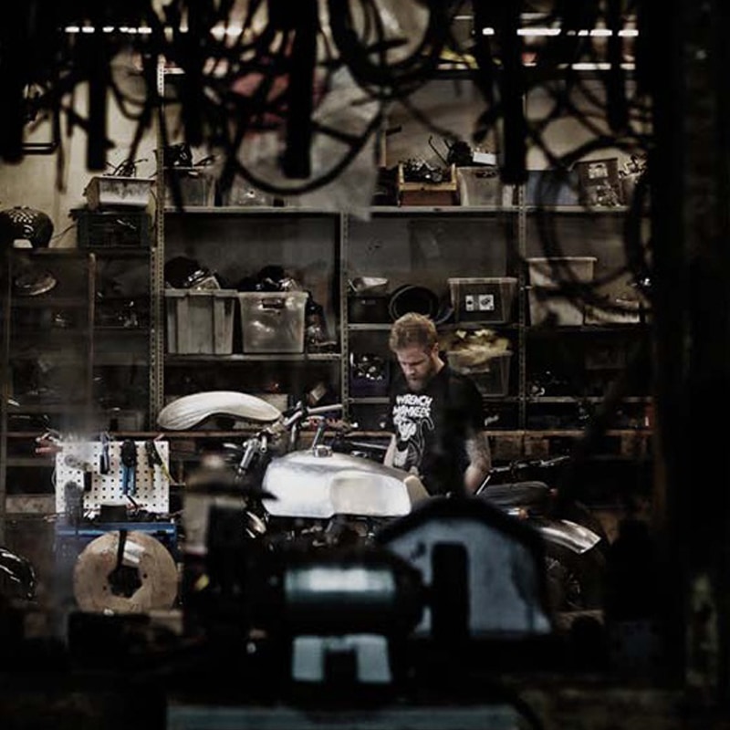 Man in a workshop with motorbike