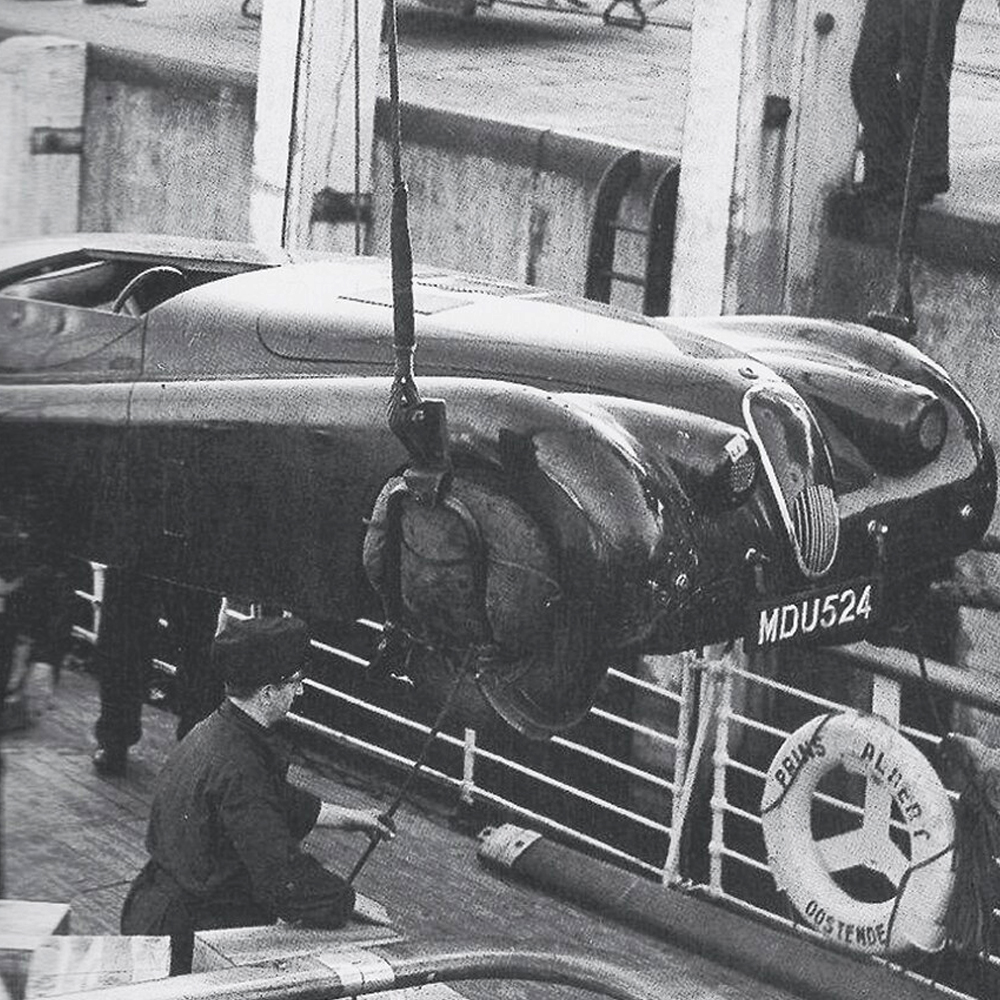 Vintage jaguar being lowered onto a boat