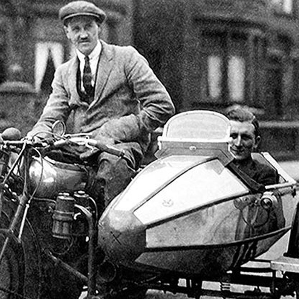 Two men on motorbike with side car