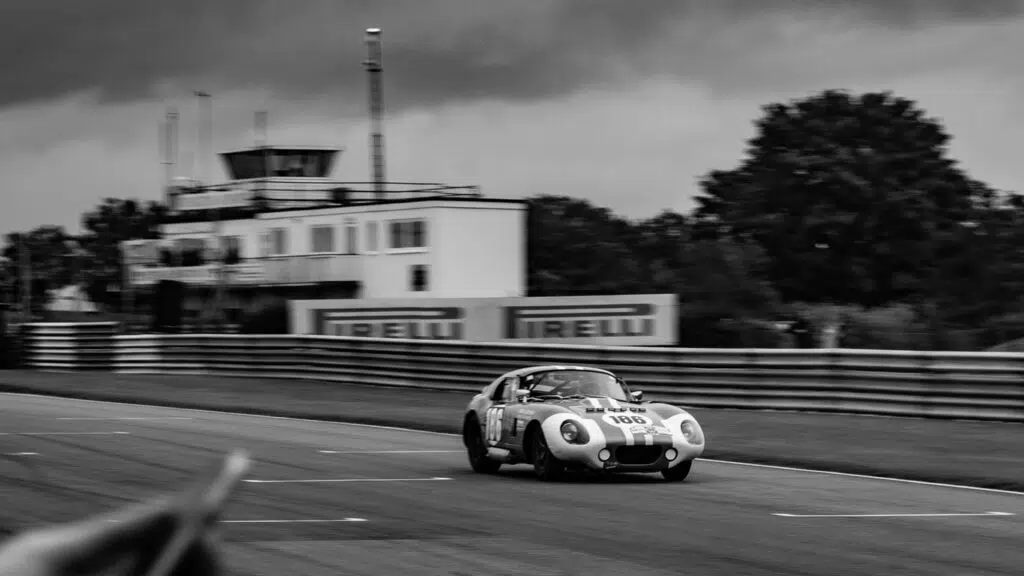Black and white picture of car racing on track