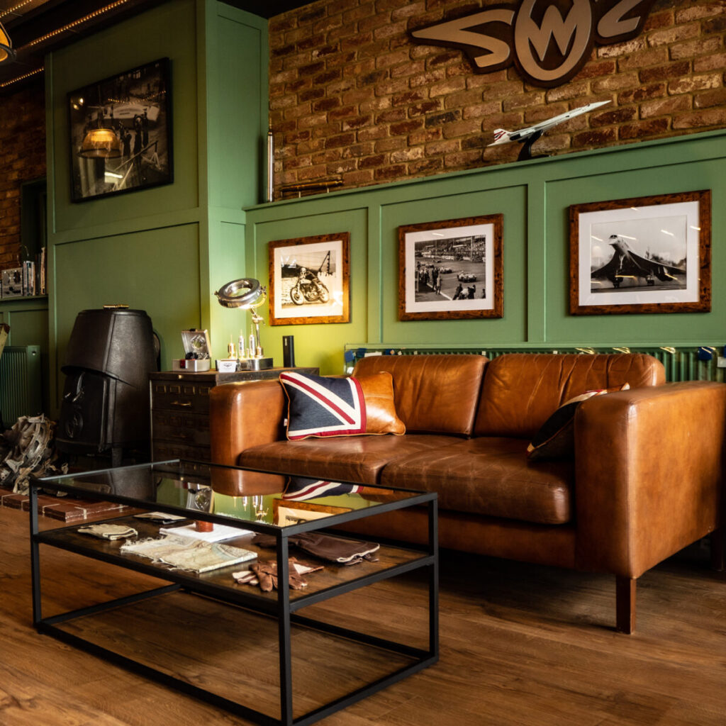 interior studio photo with sofa and coffee table with pictures on wall behind