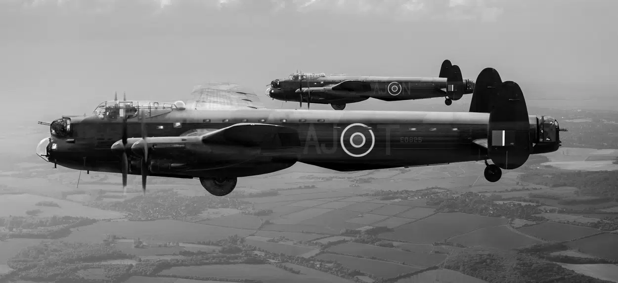 Two Lancaster Bombers flying over the British countryside