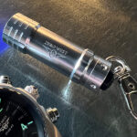 Mini ultraviolet torch next to DB2 watch