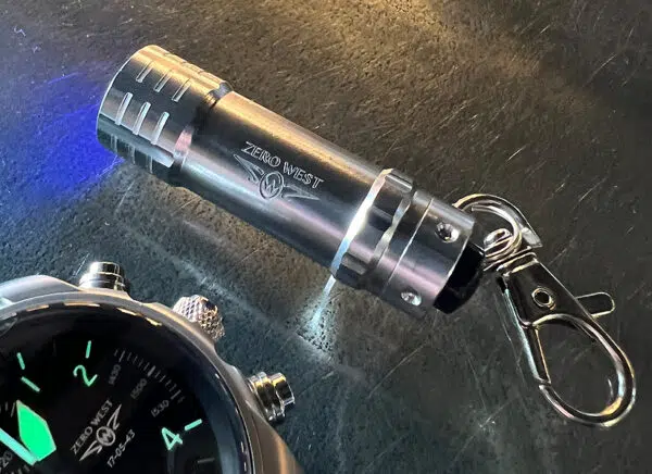 Mini ultraviolet torch next to DB2 watch