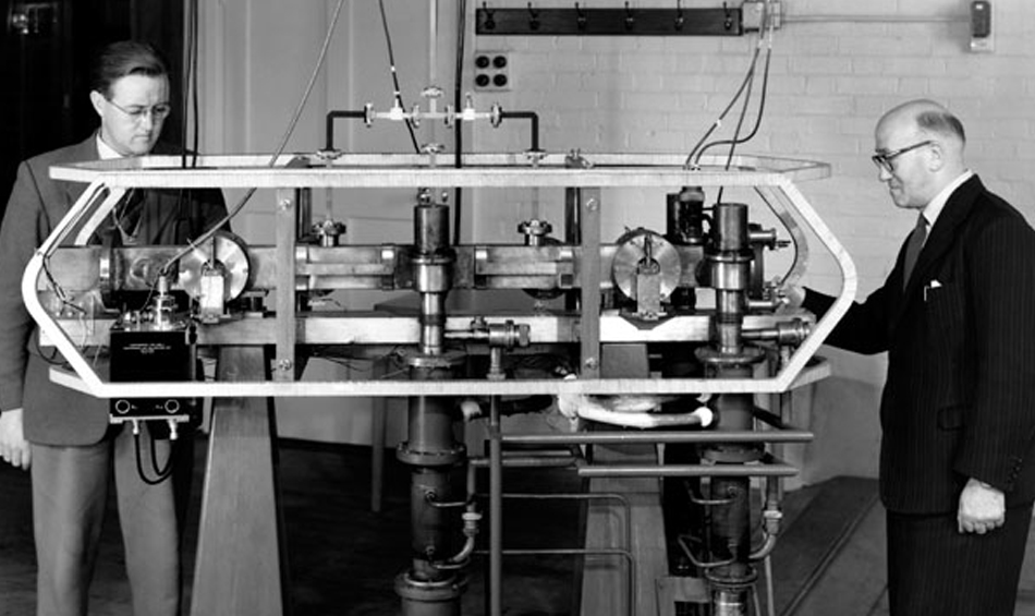 Two men standing by atomic clock