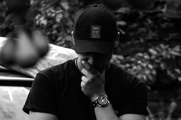 Man in cap, thoughtful expression.